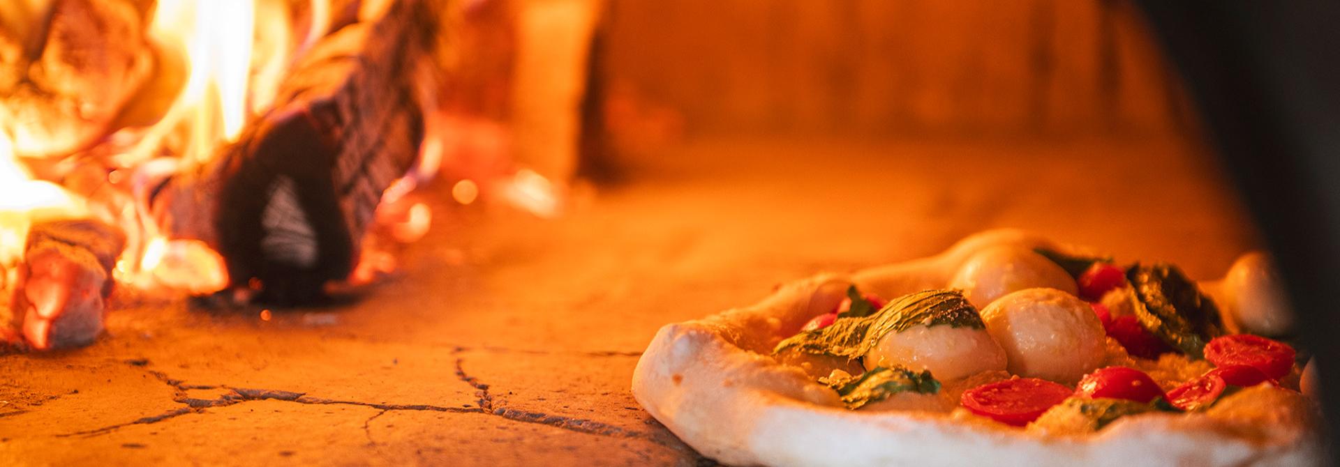 Pizza in forno a legna con pomodori e basilico.